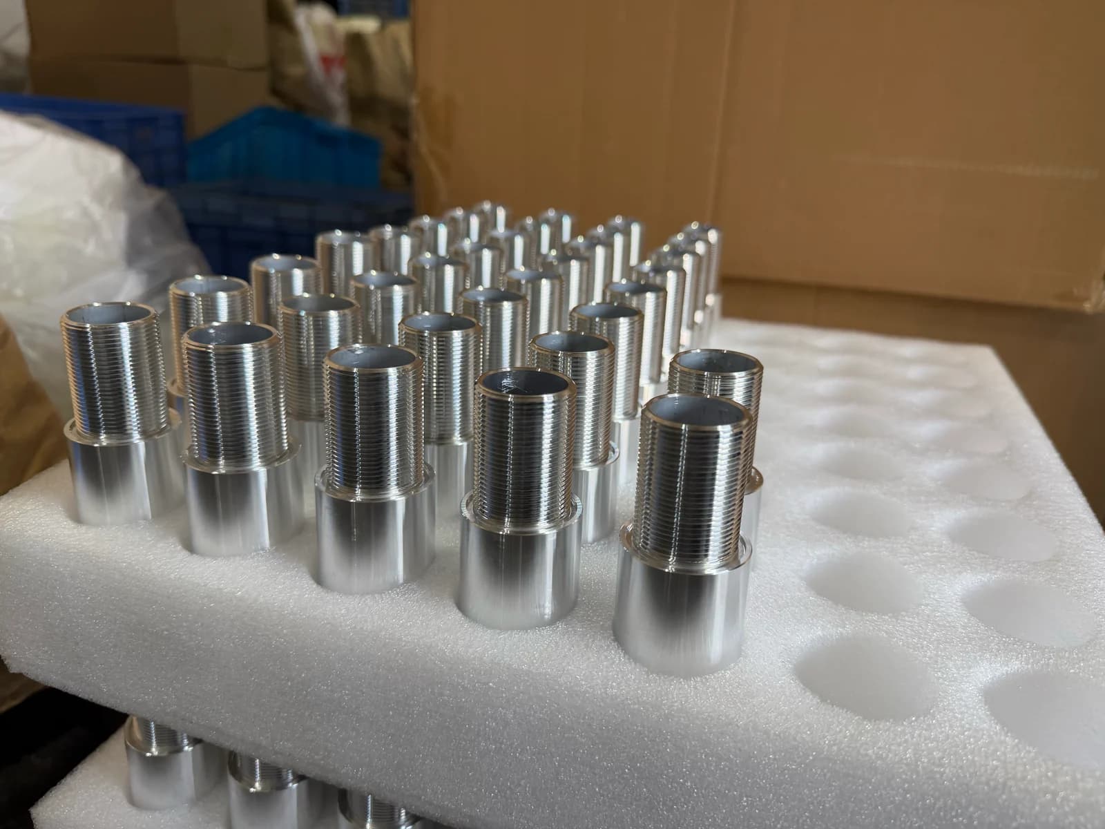 Threaded cylindrical turned parts standing in a foam packaging insert