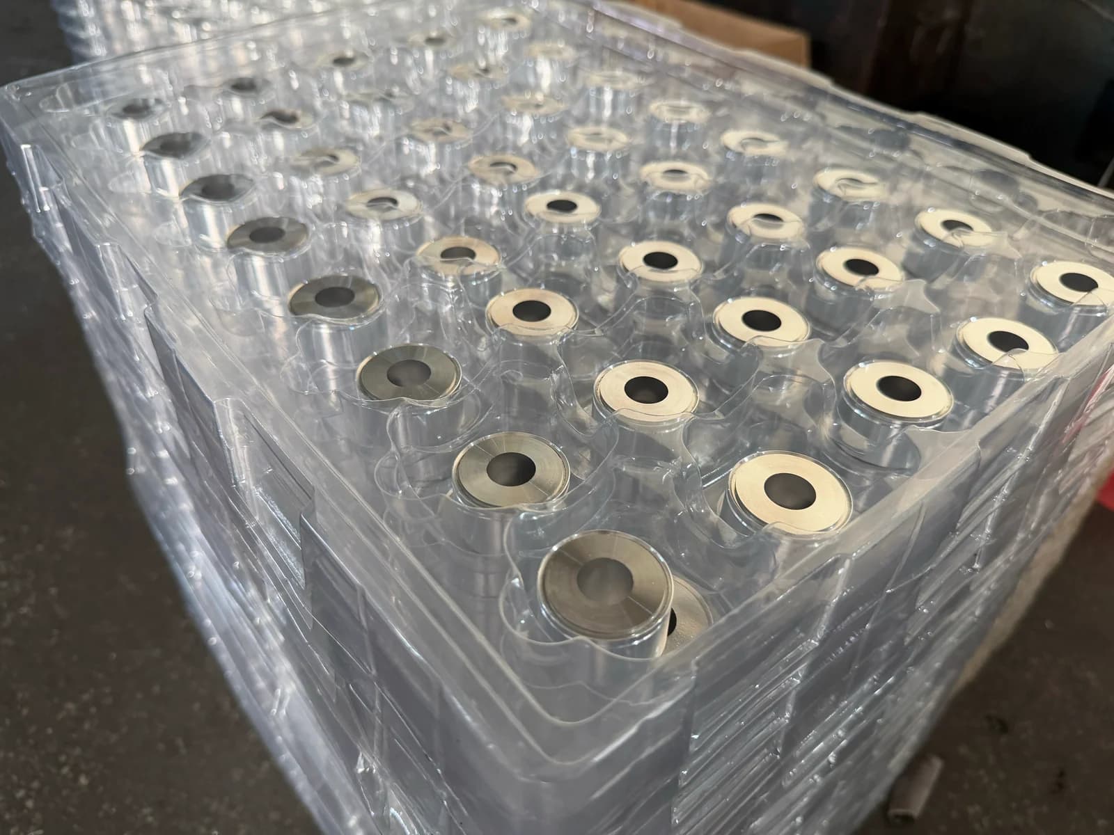 Turned bushings with center bores held in stacked clear blister trays