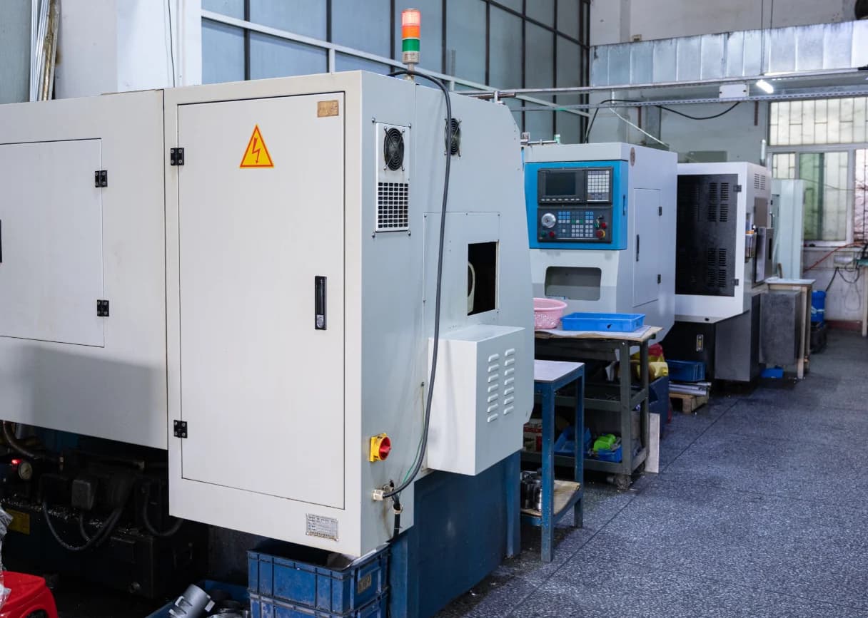 Enclosed CNC lathes arranged along an aisle in Yiwei’s workshop